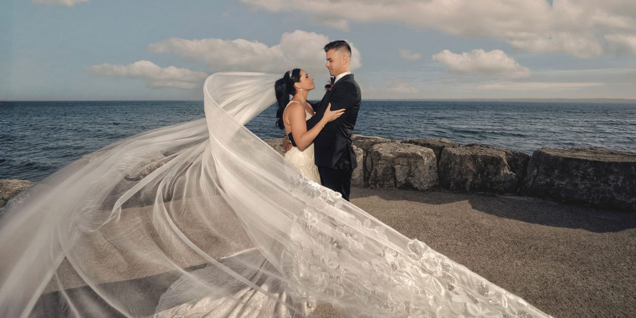A cinematic photo of a Bride and Groom with an epic veil blowing in the wind
