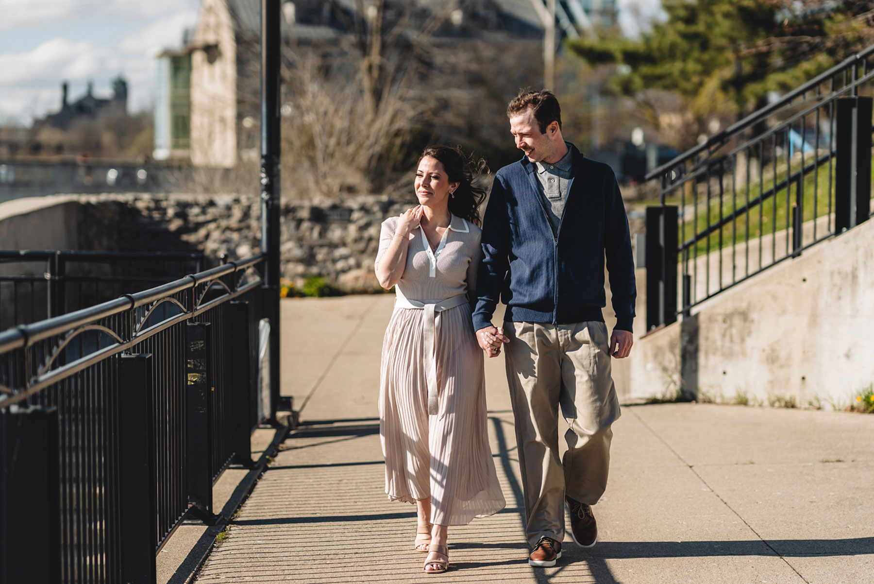 A couple on their engagement shoot, with an urban landscape in the background.