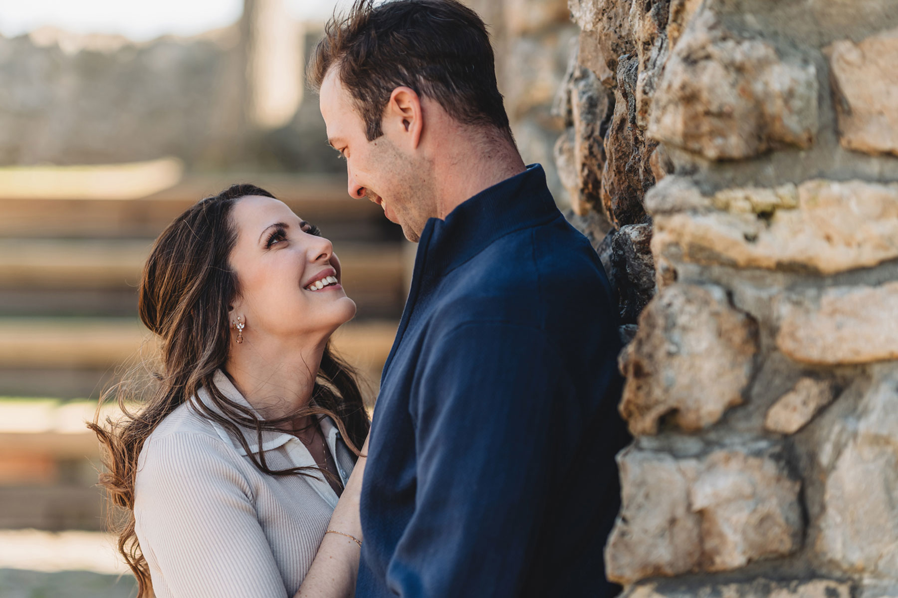 A couple on their engagement shoot, with an urban landscape in the background.