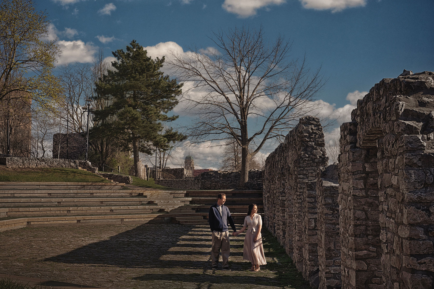 A couple on their engagement shoot, with an urban landscape in the background.