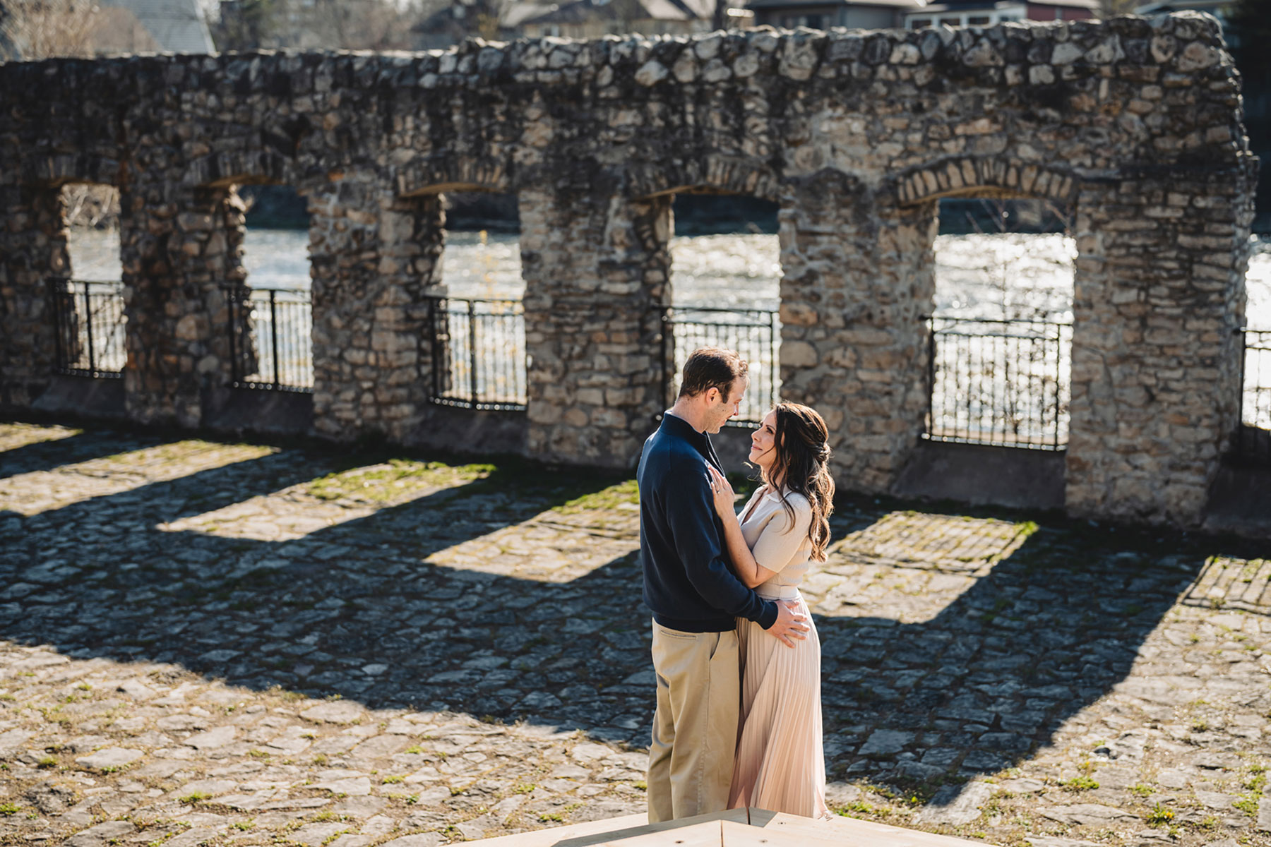 A couple on their engagement shoot, with an urban landscape in the background.