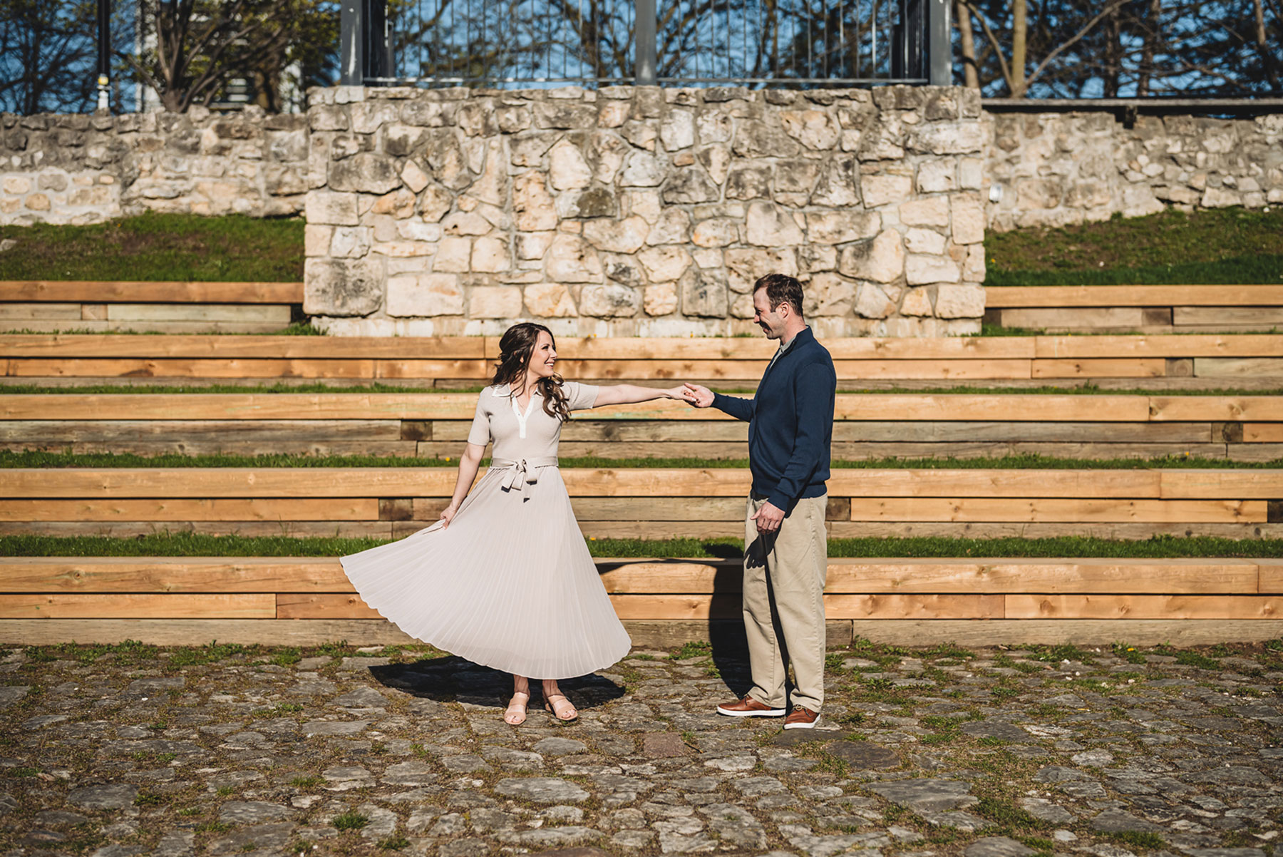 A couple on their engagement shoot, with an urban landscape in the background.