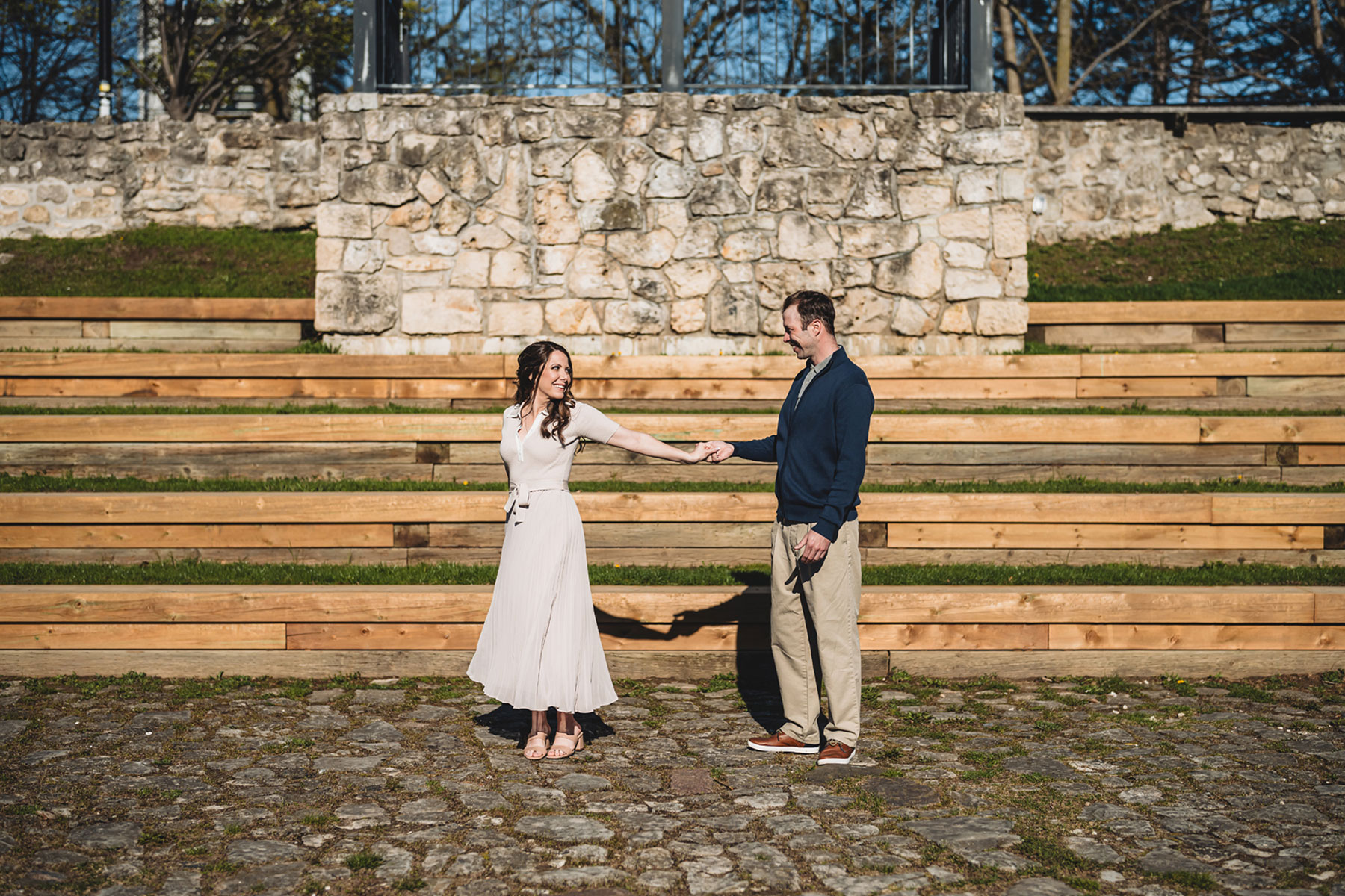 A couple on their engagement shoot, with an urban landscape in the background.