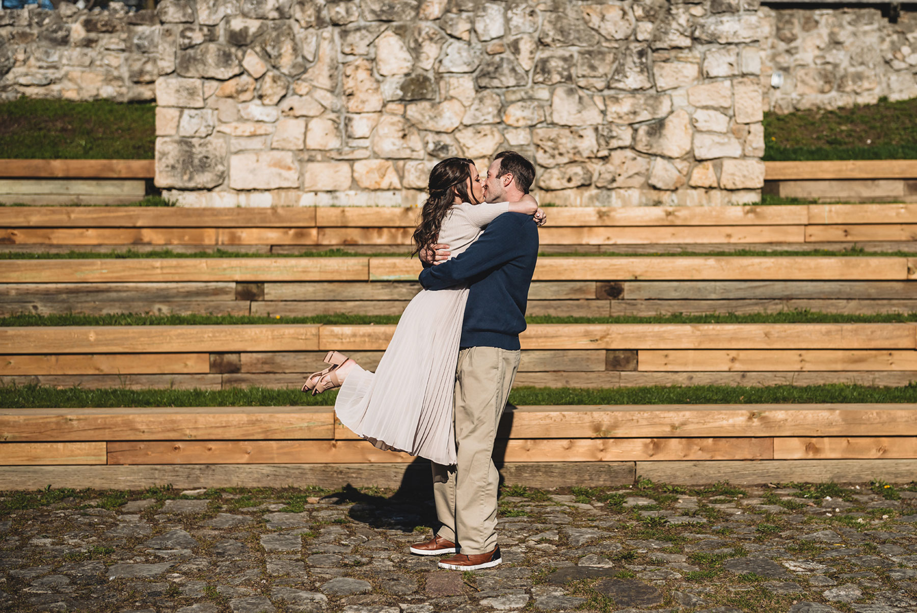 A couple on their engagement shoot, with an urban landscape in the background.