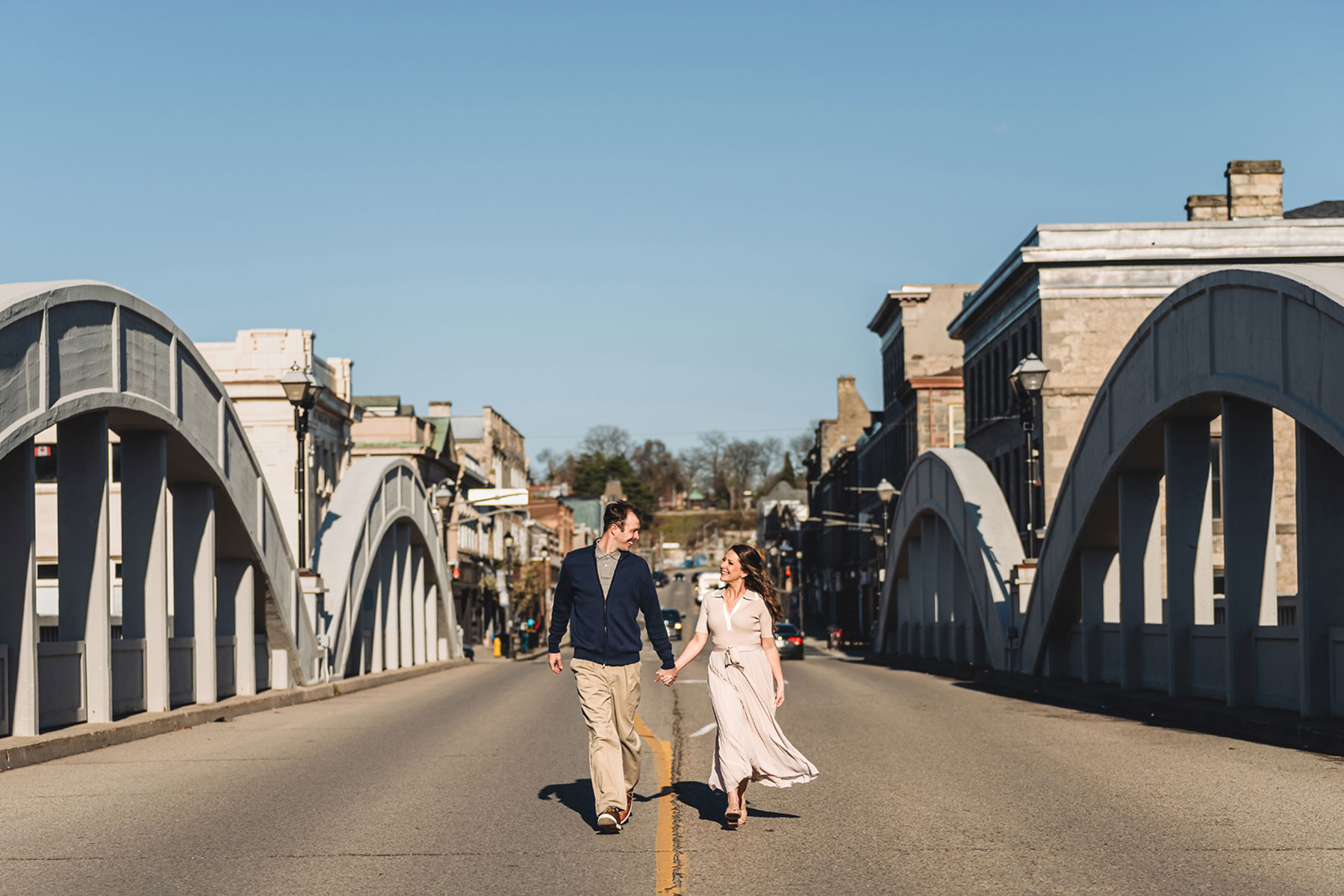 A couple on their engagement shoot, with an urban landscape in the background.