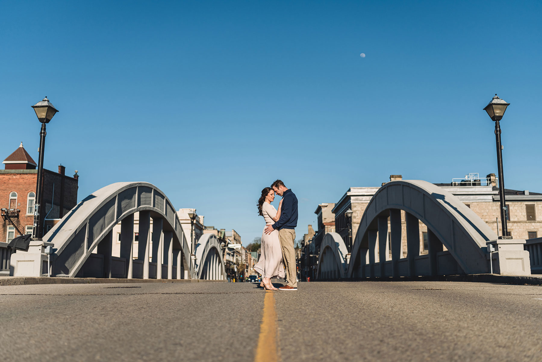 A couple on their engagement shoot, with an urban landscape in the background.