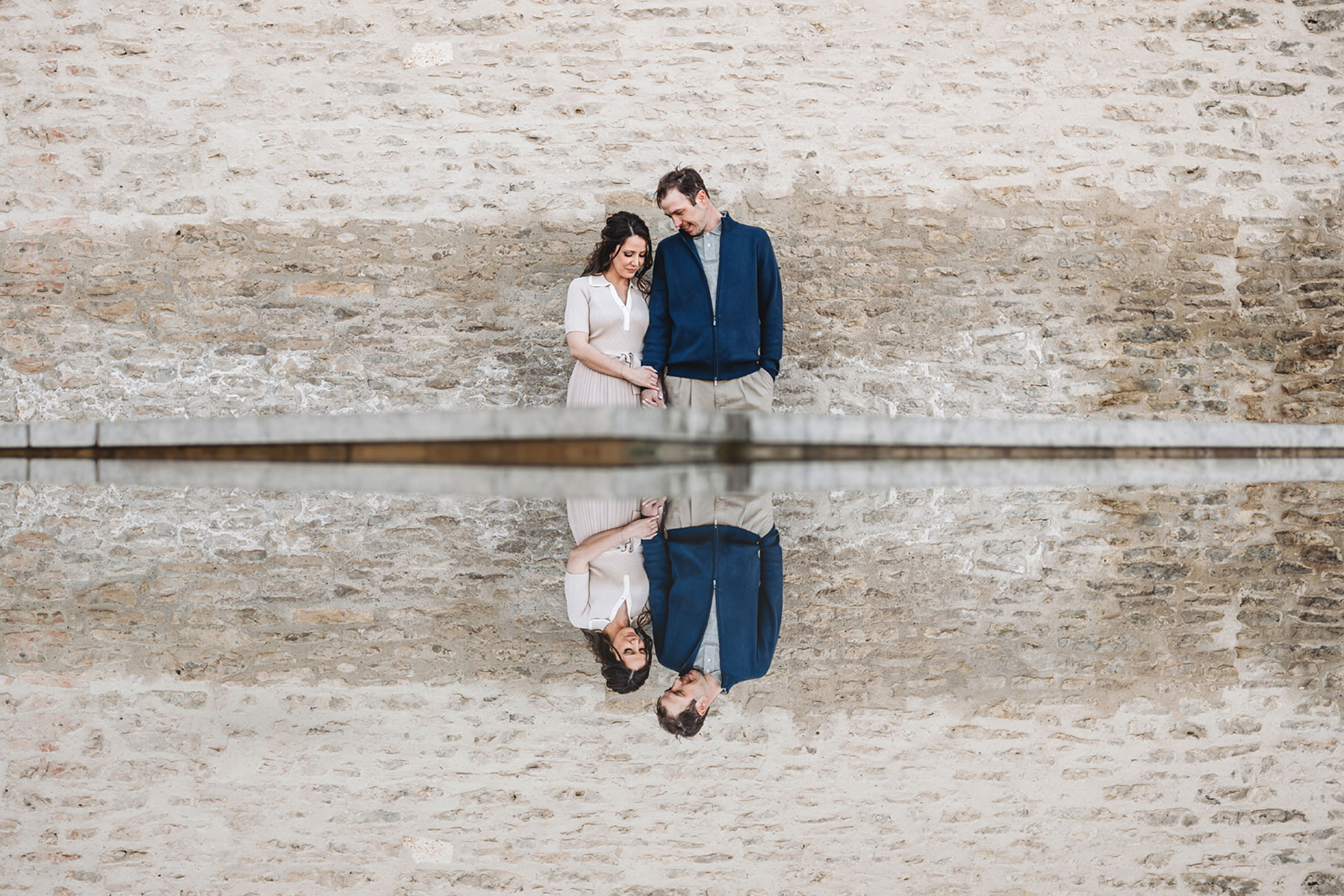 A couple on their engagement shoot, with an urban landscape in the background.