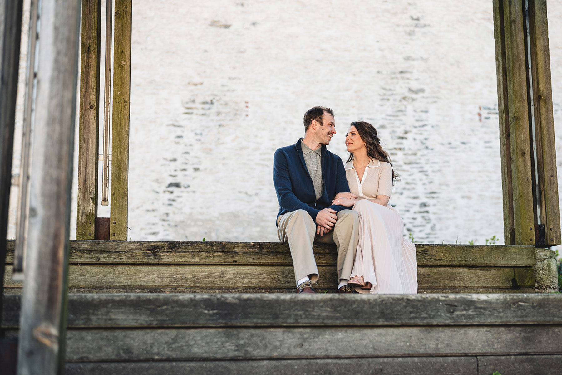 A couple on their engagement shoot, with an urban landscape in the background.