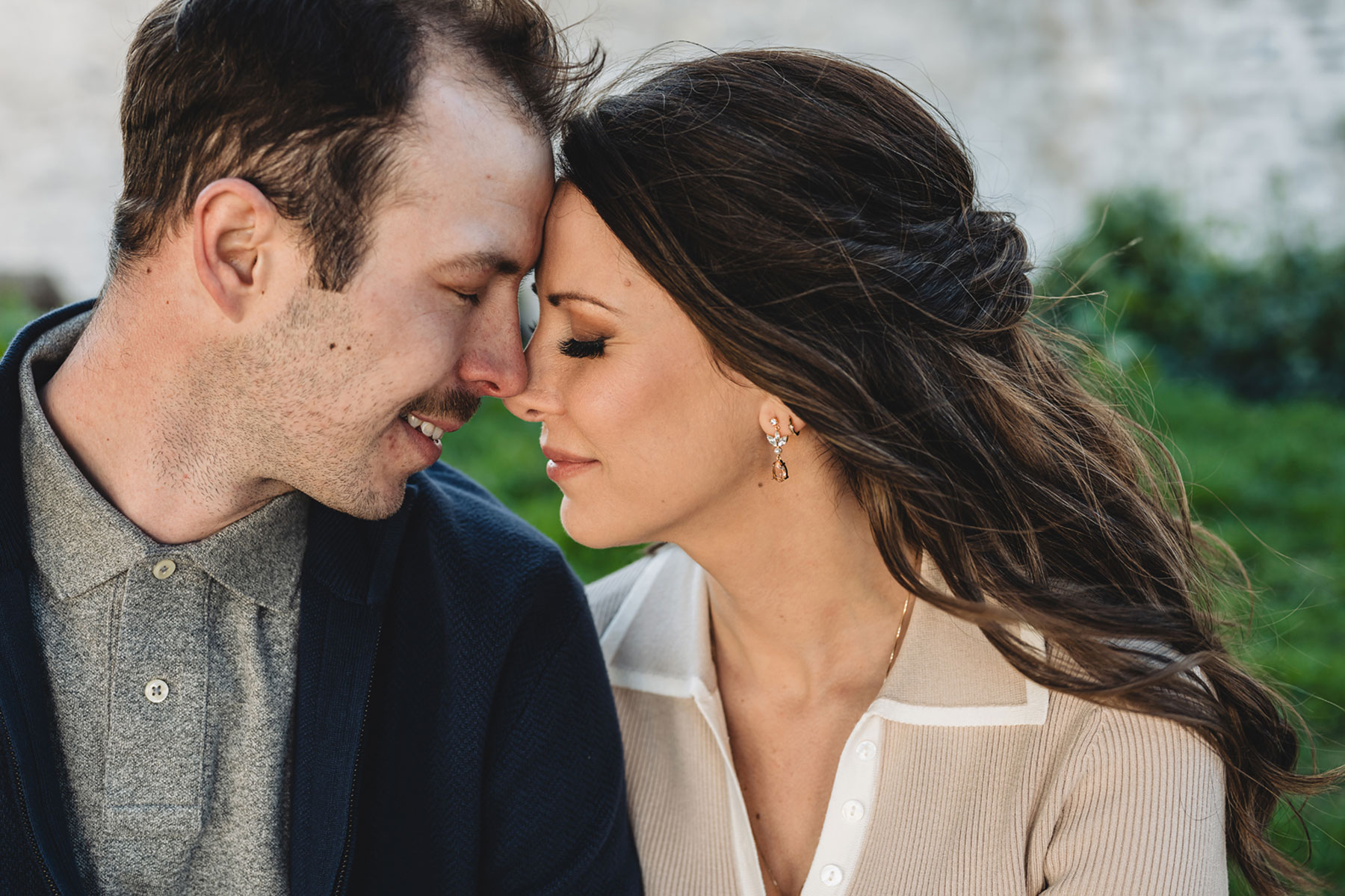 A couple on their engagement shoot, with an urban landscape in the background.