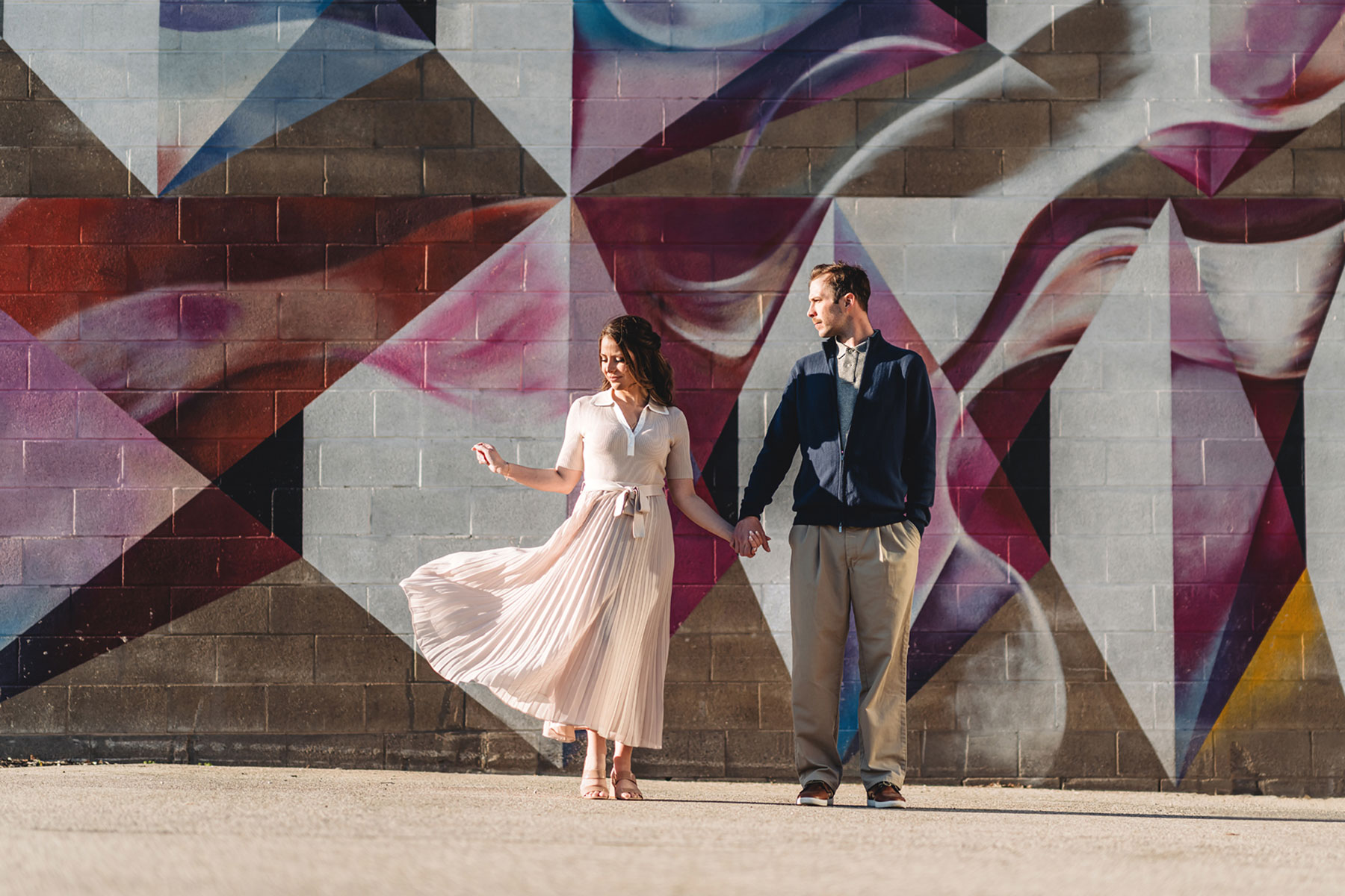 A couple on their engagement shoot, with an urban landscape in the background.