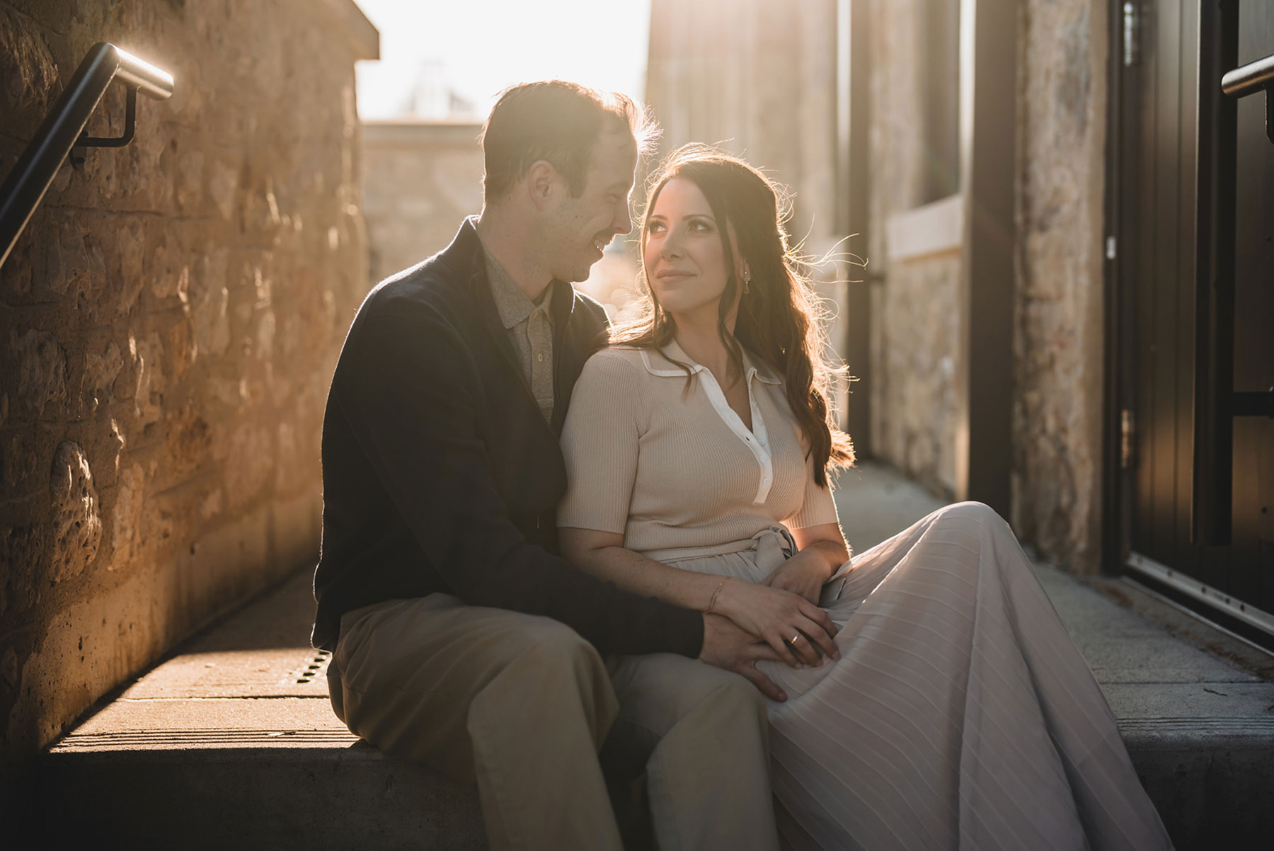 A couple on their engagement shoot, with an urban landscape in the background.