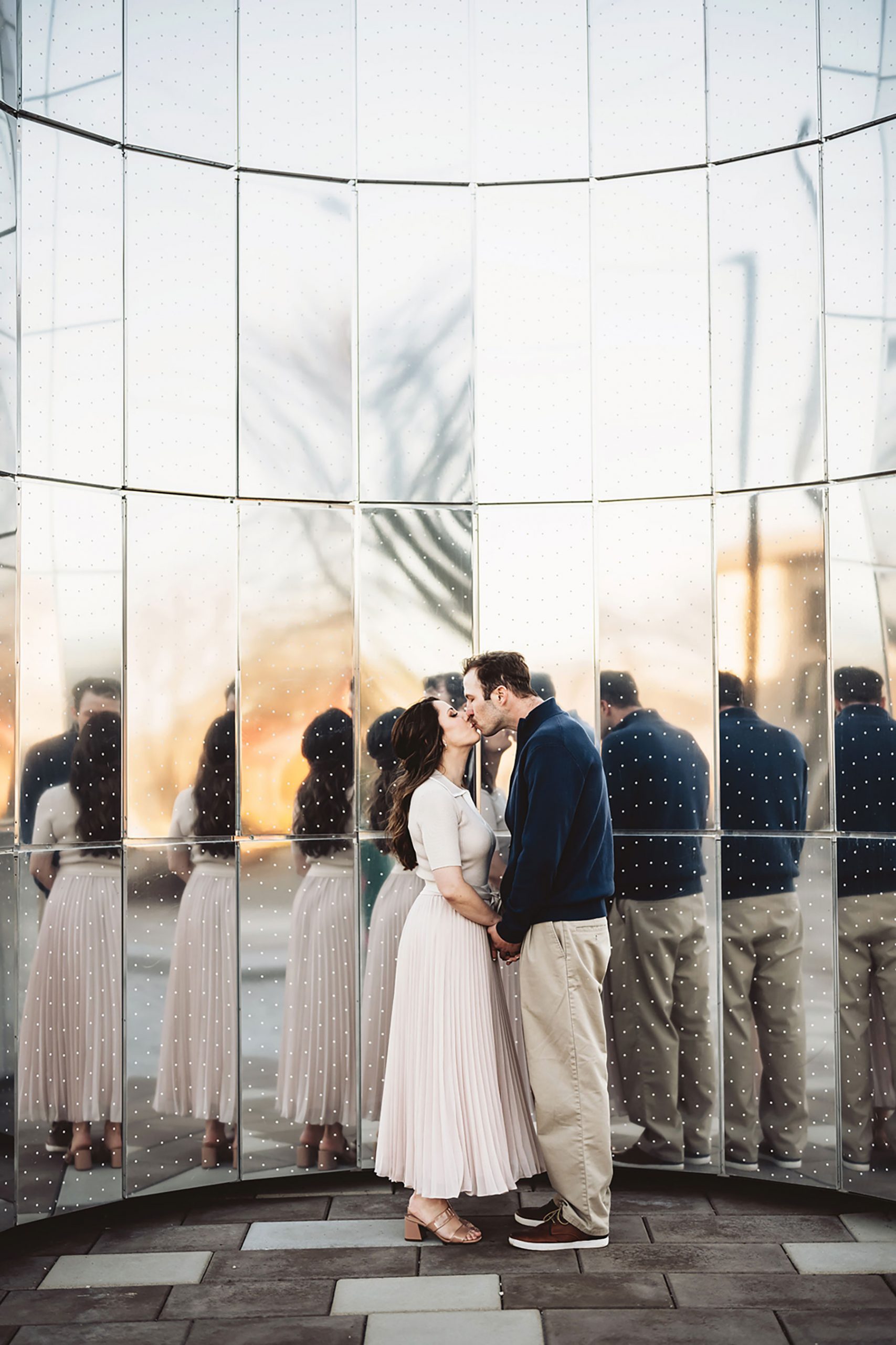 A couple on their engagement shoot, with an urban landscape in the background.