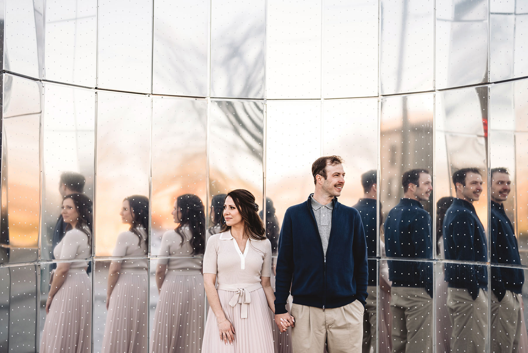 A couple on their engagement shoot, with an urban landscape in the background.