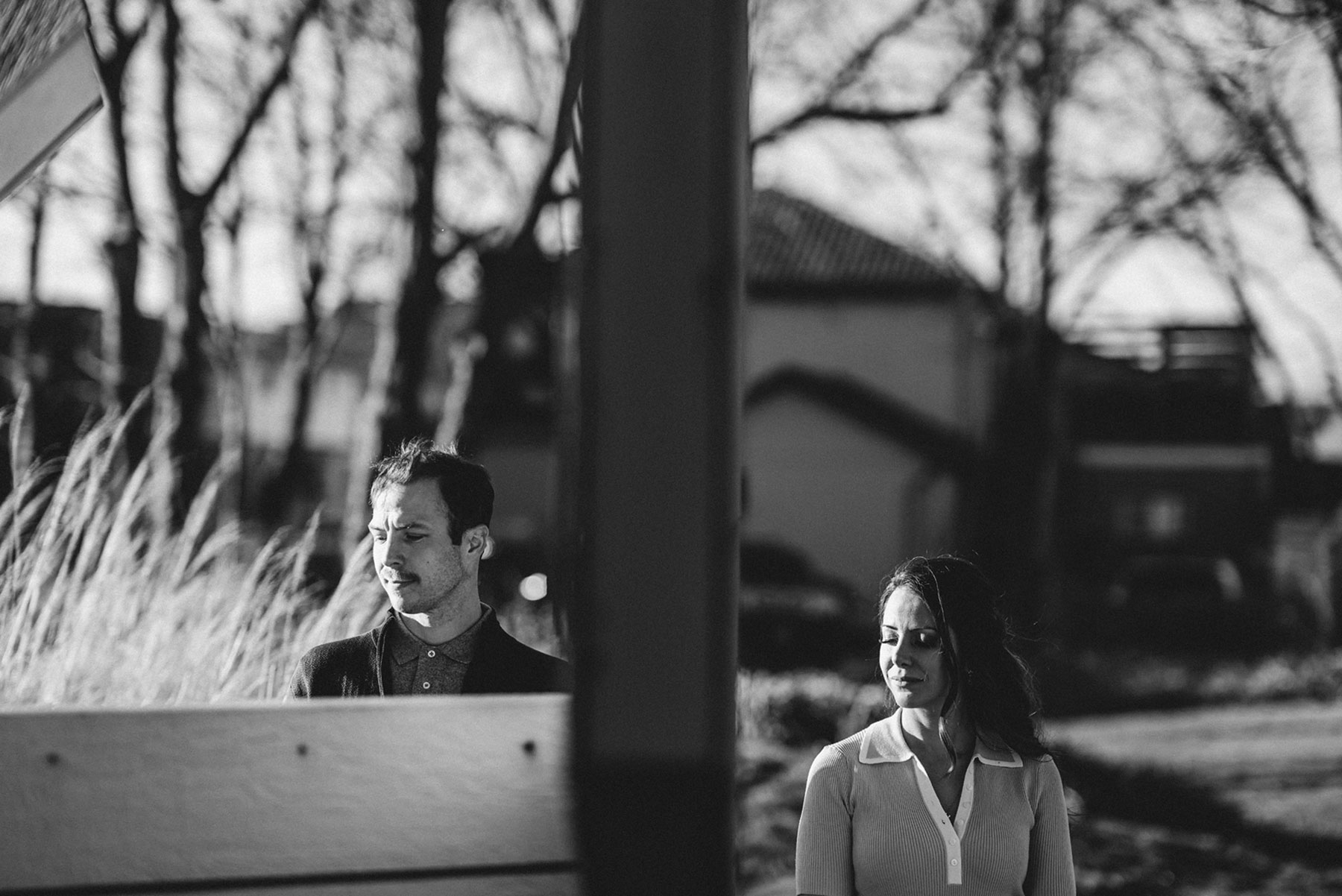 A couple on their engagement shoot, with an urban landscape in the background.