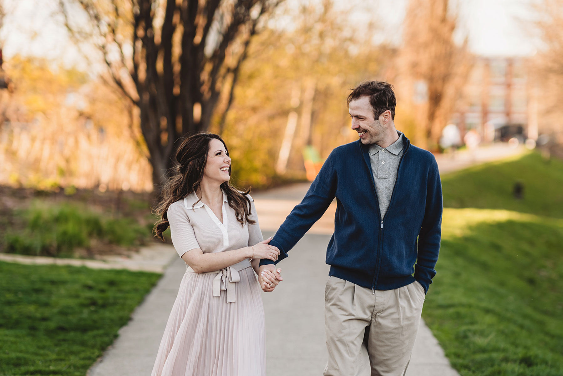 A couple on their engagement shoot, with an urban landscape in the background.