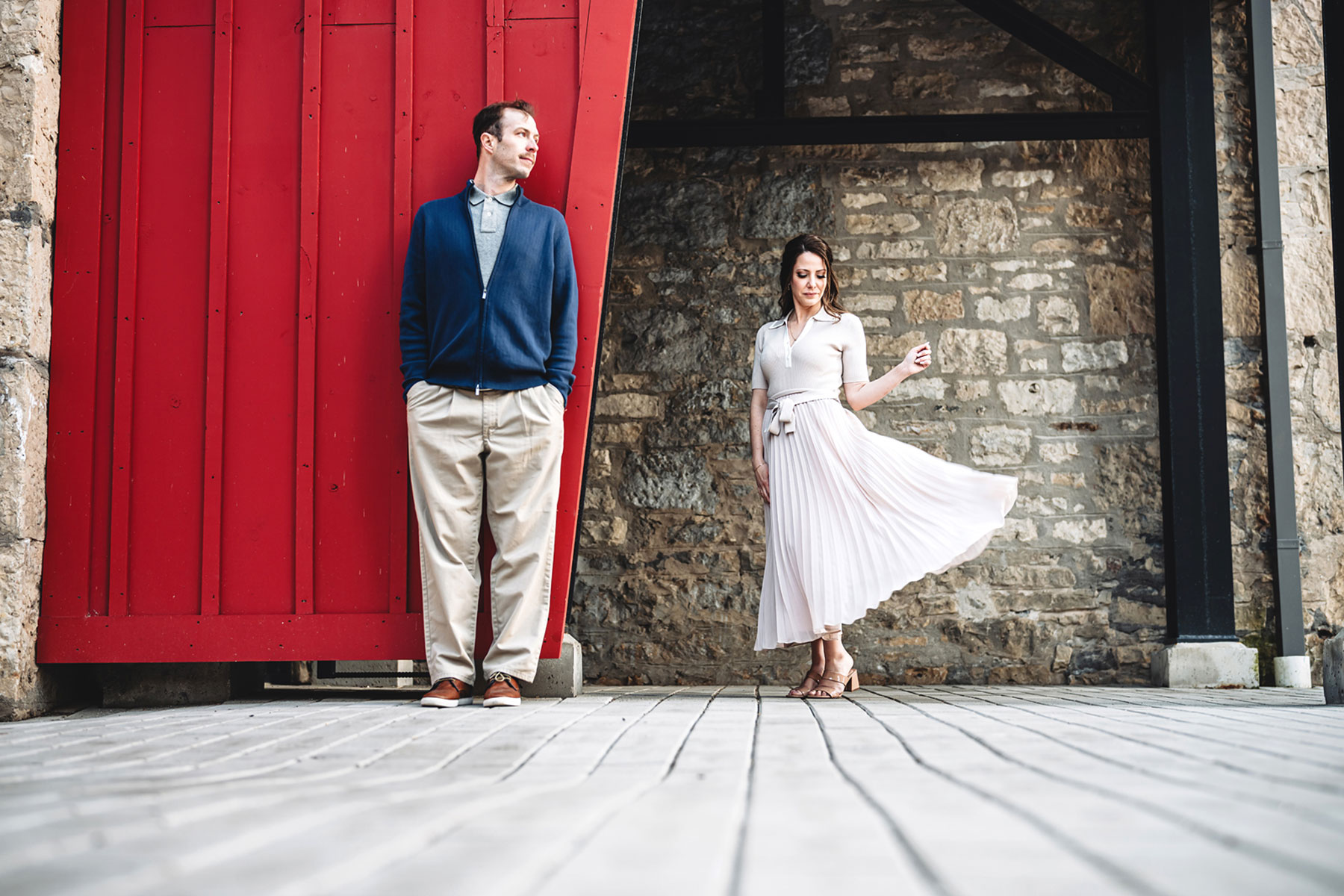 A couple on their engagement shoot, with an urban landscape in the background.