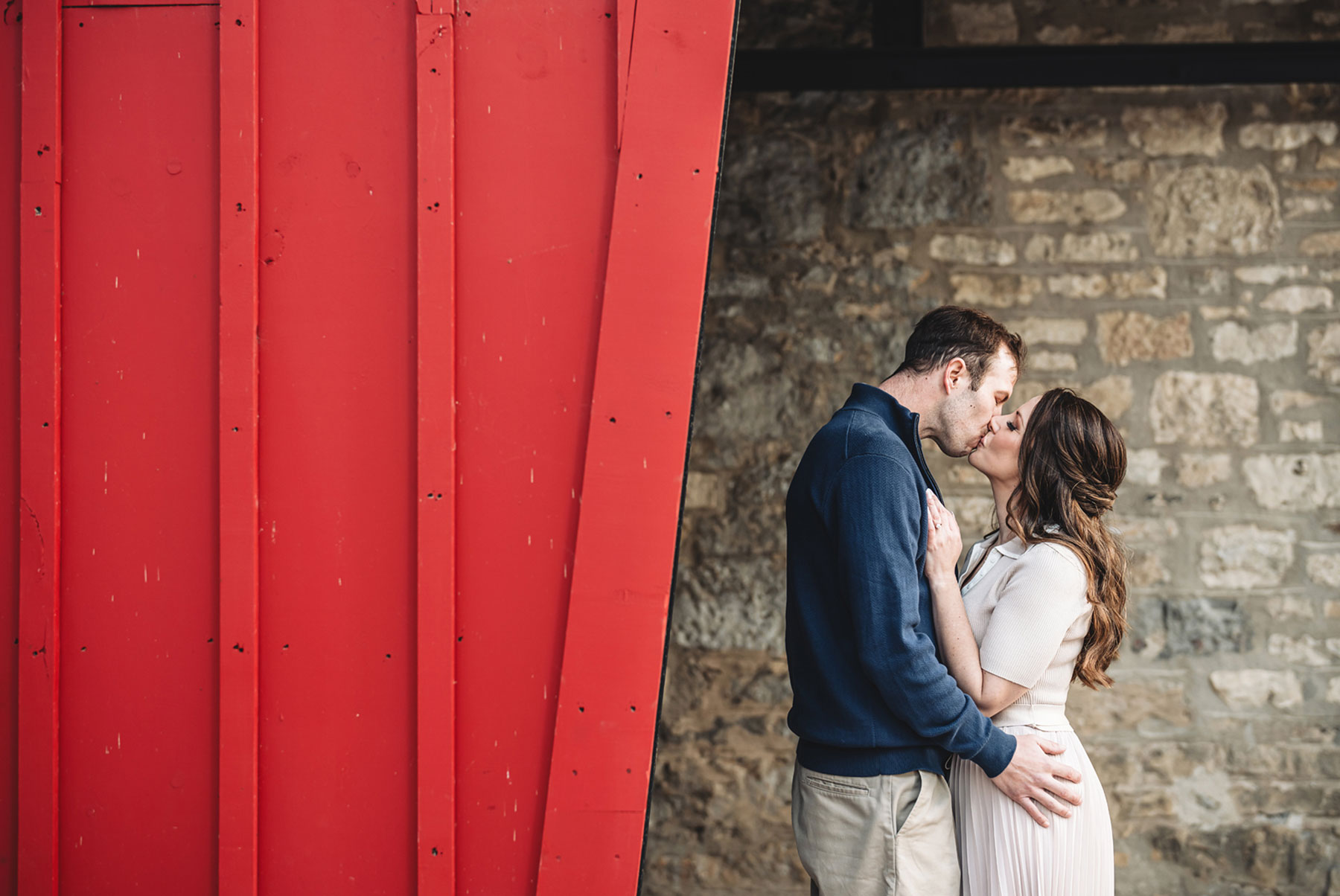 A couple on their engagement shoot, with an urban landscape in the background.