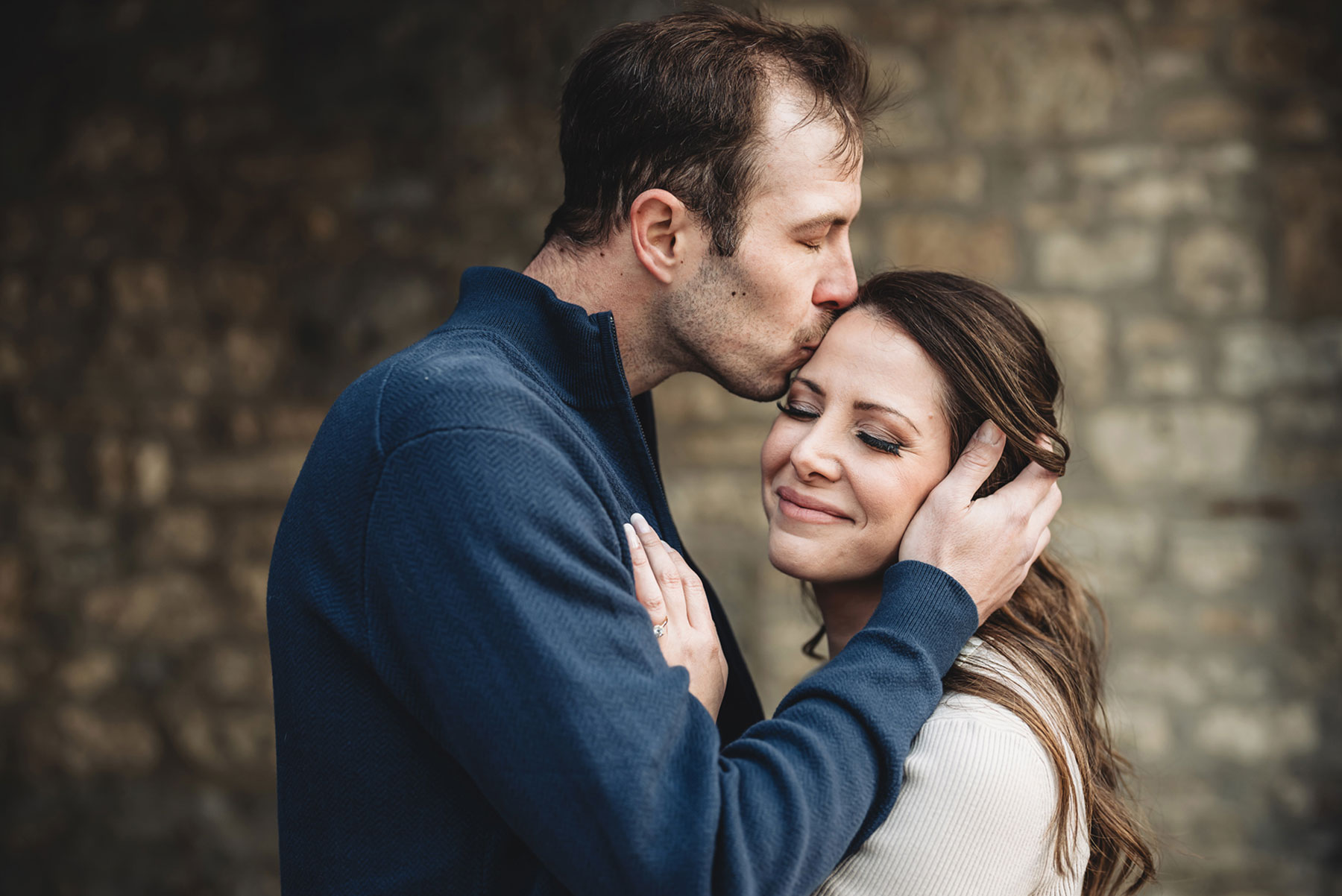 A couple on their engagement shoot, with an urban landscape in the background.