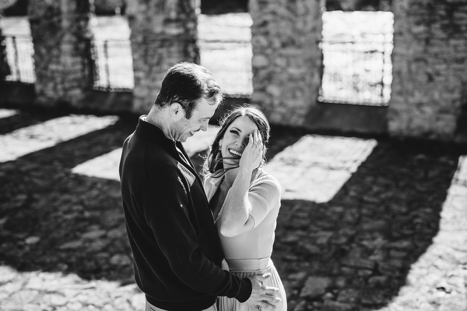 A couple on their engagement shoot, with an urban landscape in the background.