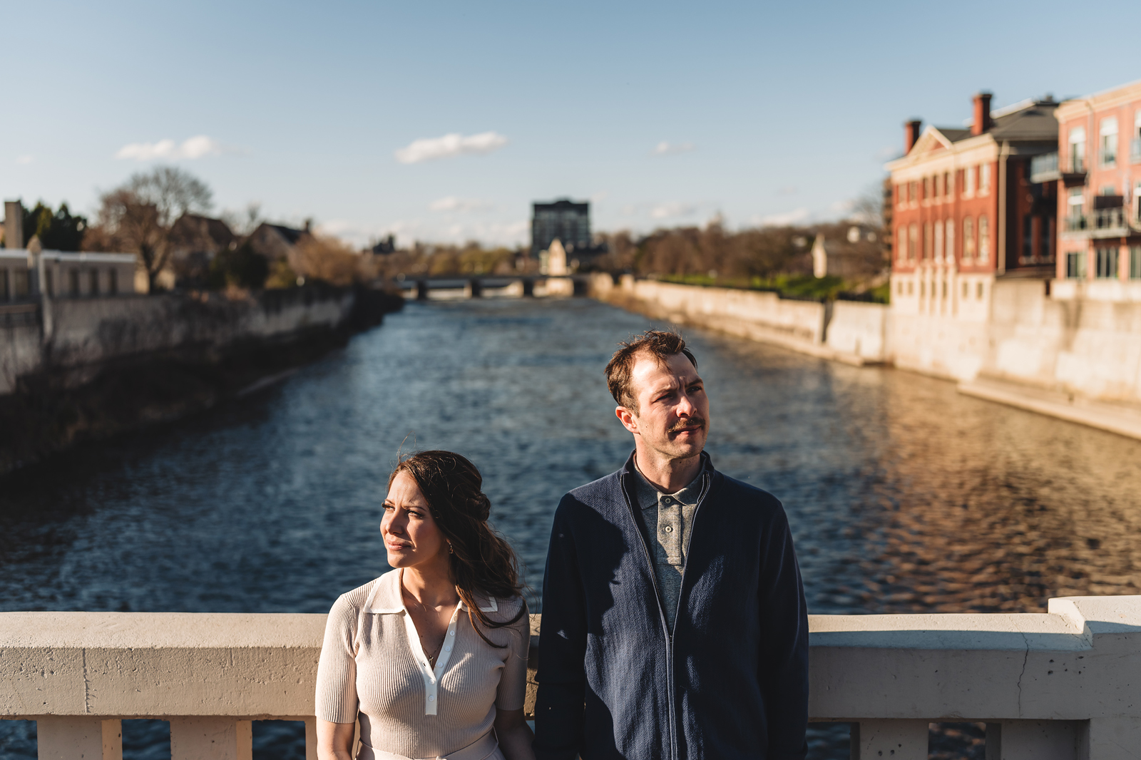 A couple on their engagement shoot, with an urban landscape in the background.