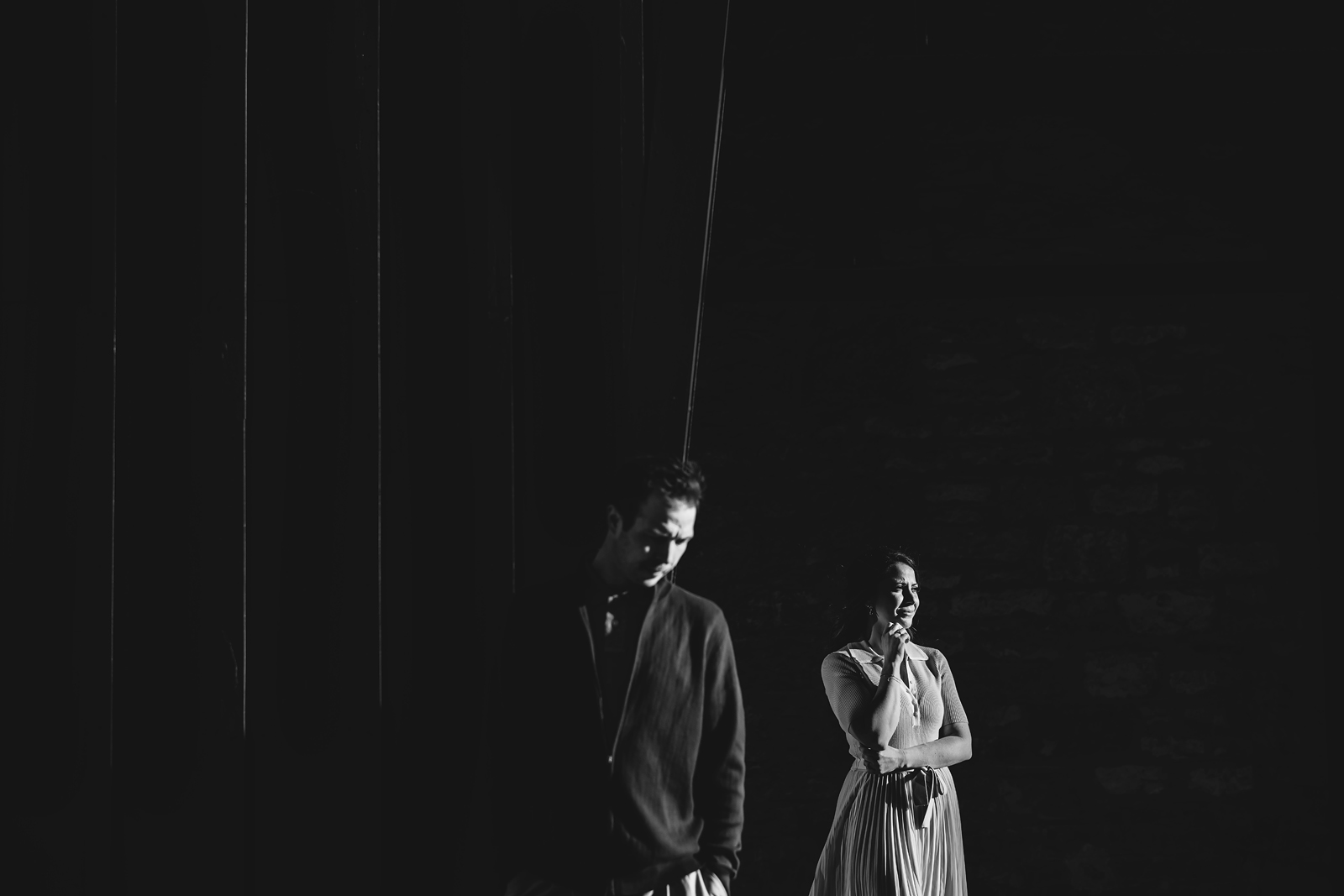 A couple on their engagement shoot, with an urban landscape in the background.