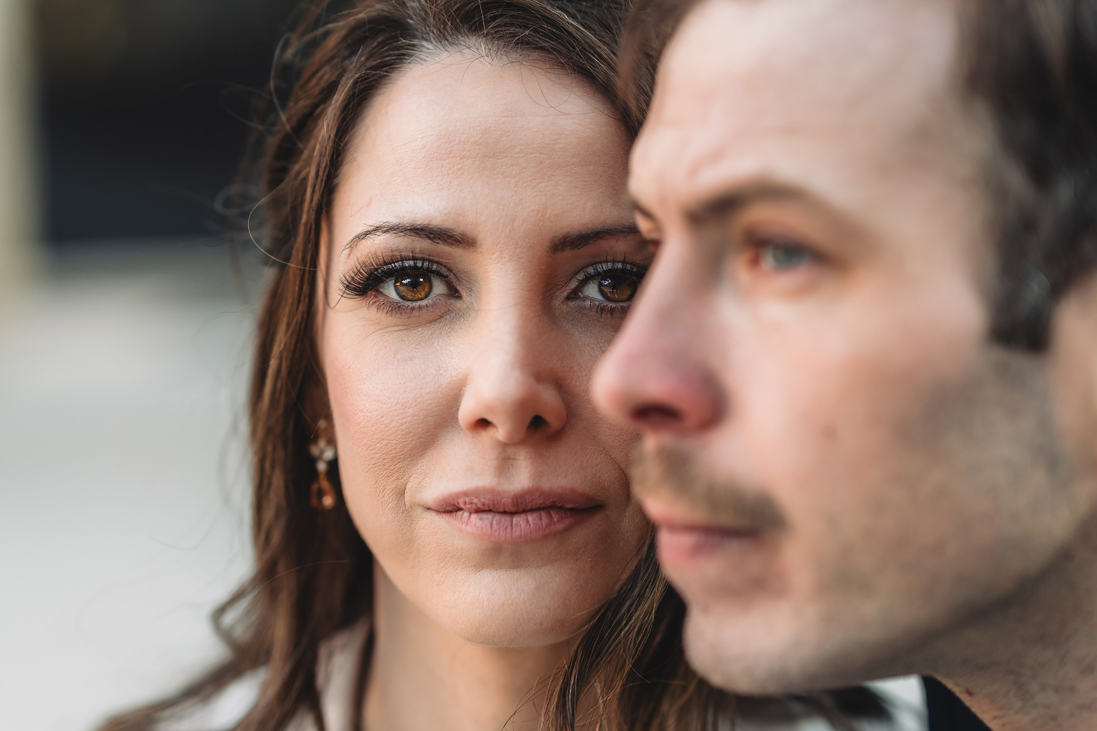 A couple on their engagement shoot, with an urban landscape in the background.