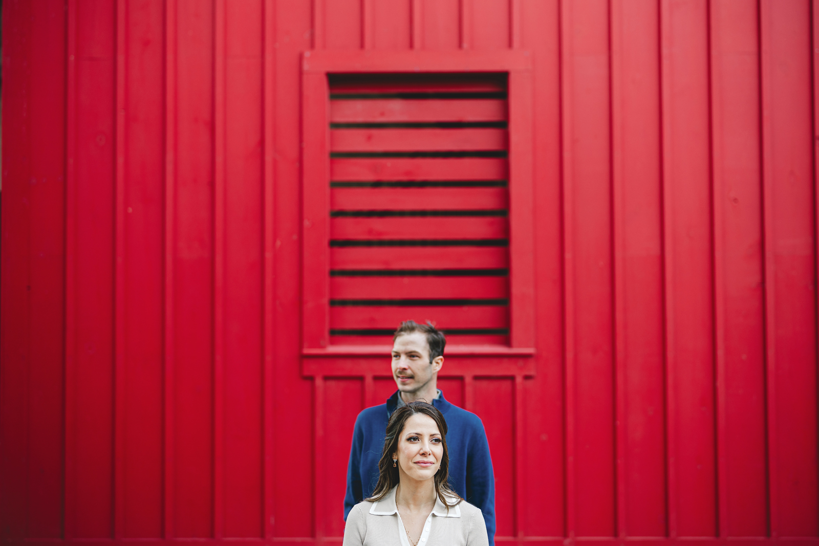 A couple on their engagement shoot, with an urban landscape in the background.